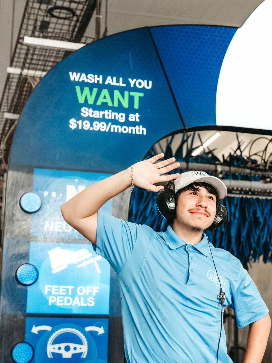 employee standing in front of carwash storefront